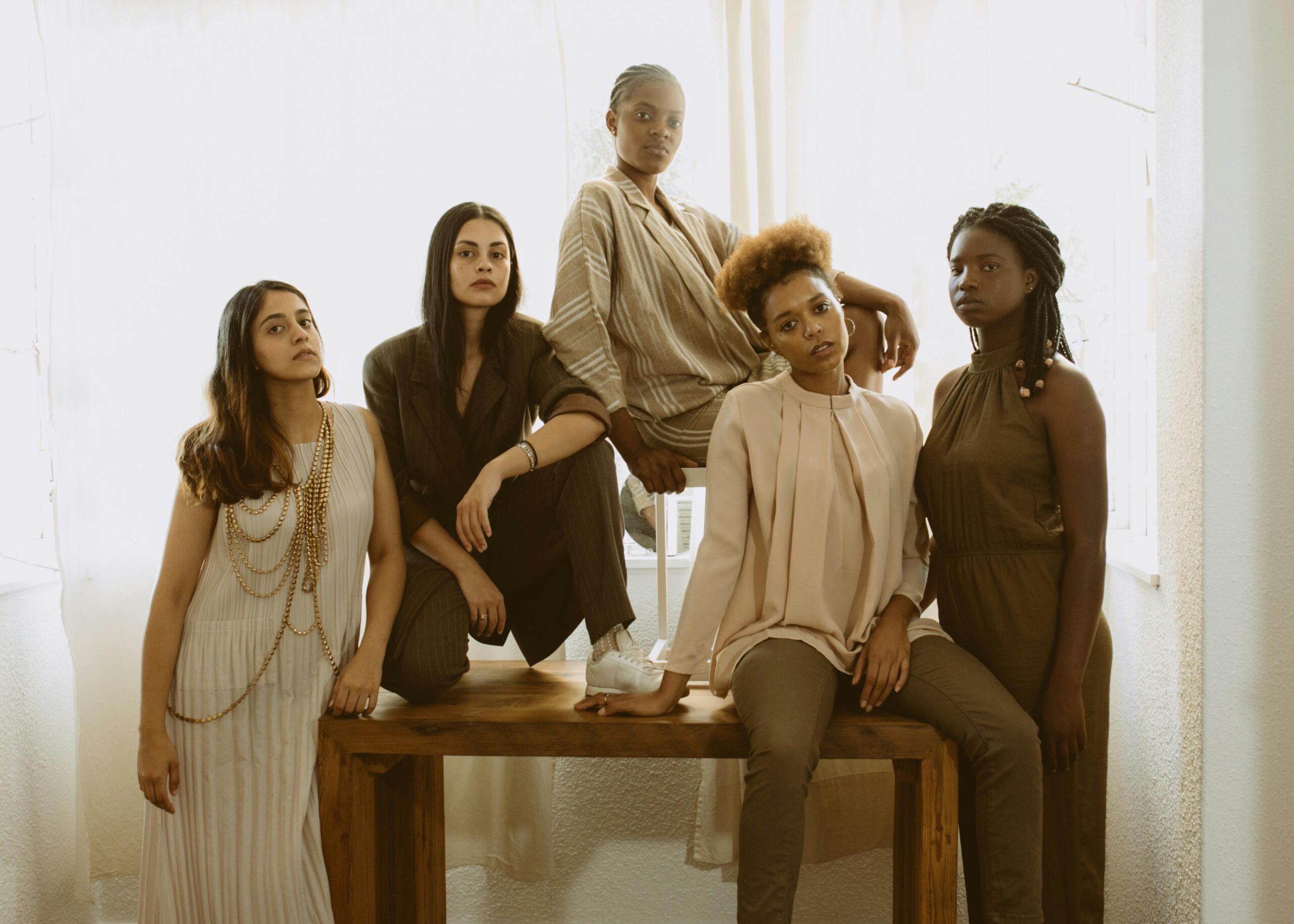 Five diverse women in fashionable outfits representing empowerment and unity.