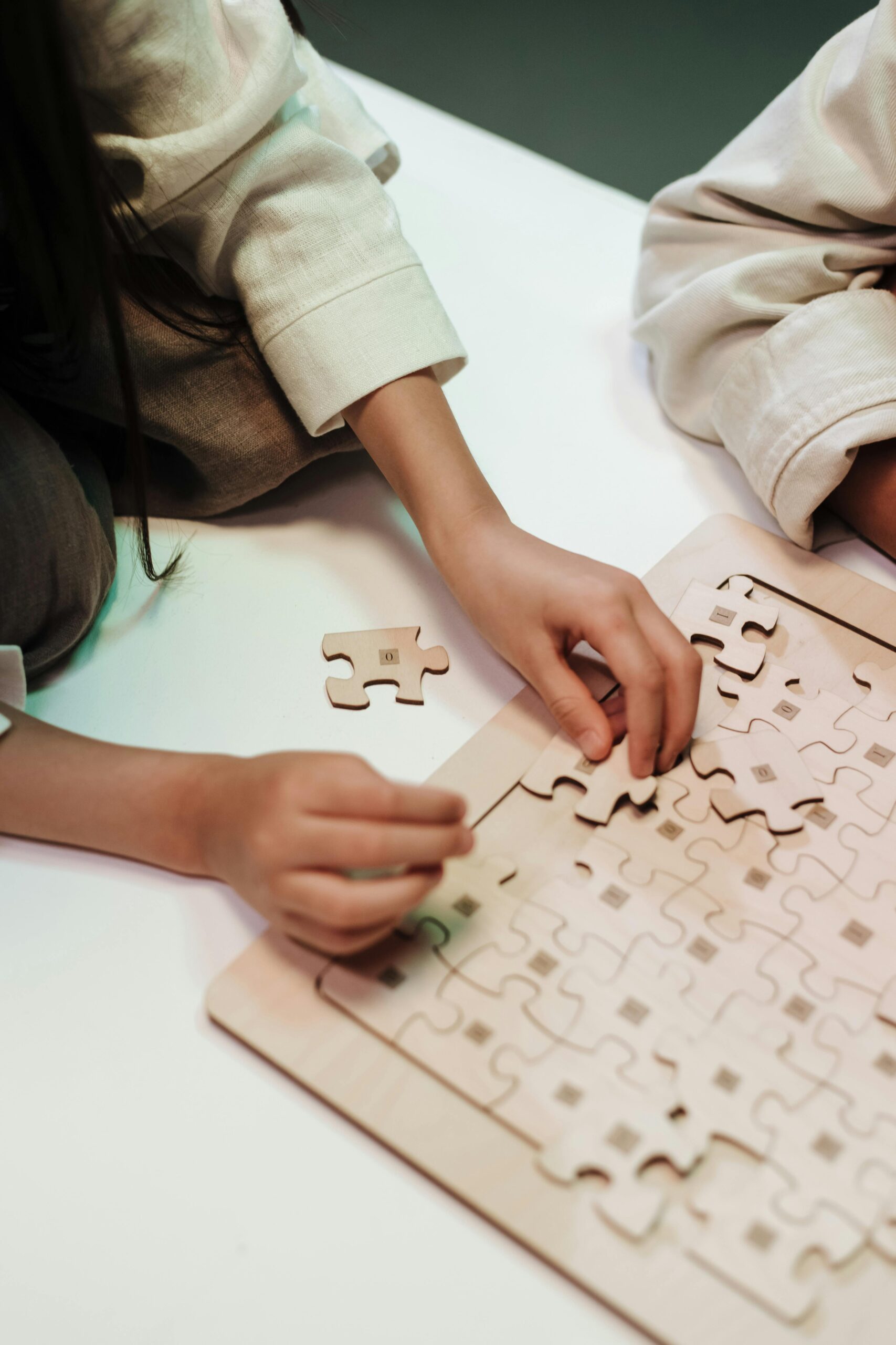 Kids assembling a jigsaw puzzle indoors, emphasizing teamwork and creativity.